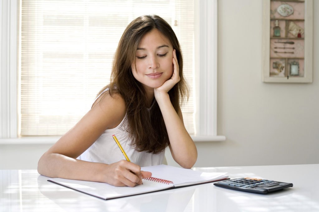 woman working on maximizing her finances checking investments cleaning up credit budget spending plan tips and tricks to maximize