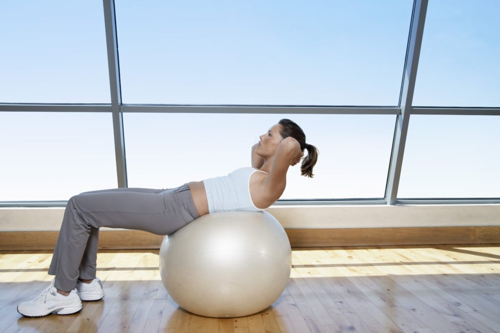woman doing sit ups, exercise to reduce stress, activity to manage stress, reduce stress after divorce, divorce is stressful, woman surviving after divorce