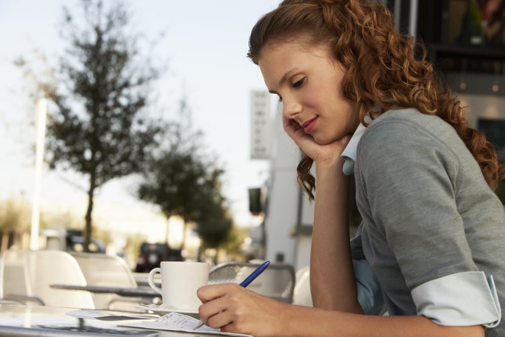 Woman writing a financial plan or a budget.